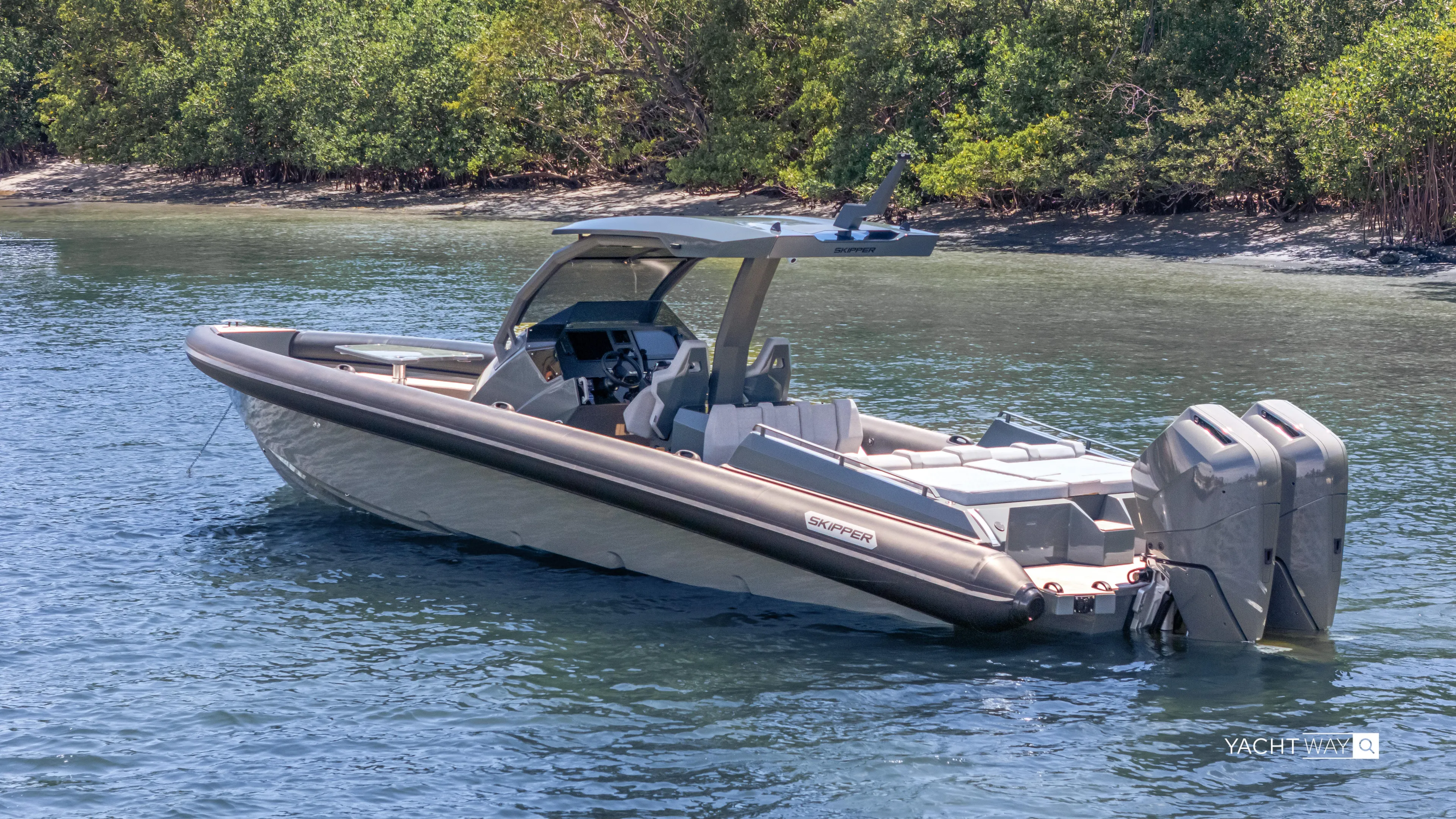 New 2025 Skipper 38 Twin Mercury 400 - Sunbed Ed Yacht Photos Pics 2025 Skipper-BSK 38NC boat on calm water near lush greenery.