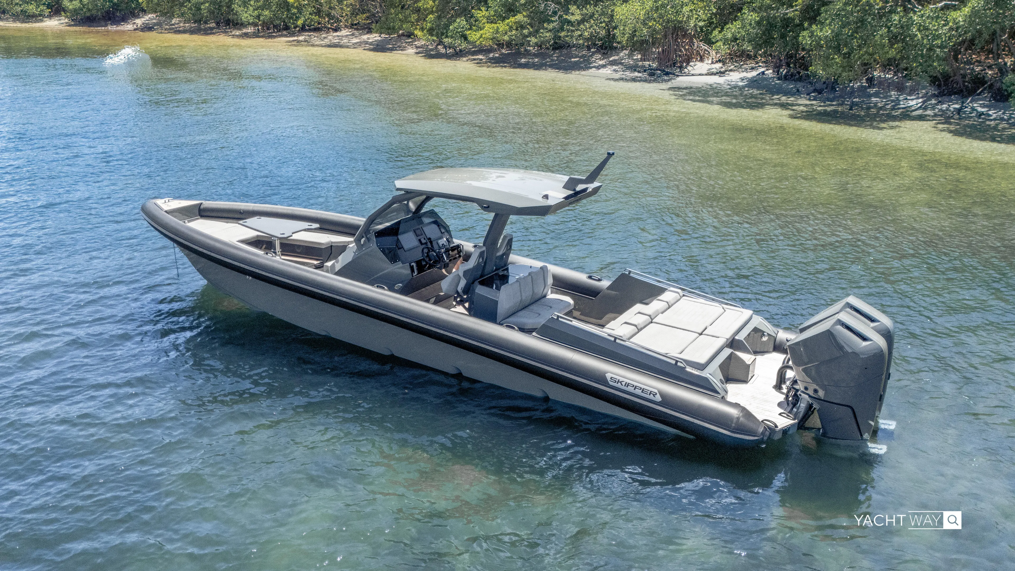 New 2025 Skipper 38 Twin Mercury 400 - Sunbed Ed Yacht Photos Pics 2025 Skipper-BSK 38NC boat in shallow water near a forested shoreline.