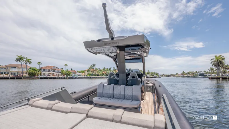New 2025 Skipper 38 Twin Mercury 400 - Sunbed Ed Yacht Photos Pics 2025 Skipper-BSK 38NC luxury boat on a scenic waterfront with palm trees.