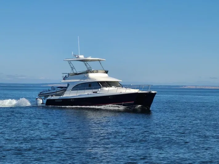  Yacht Photos Pics 2026 Aspen C128 Flybridge yacht cruising on open water under clear blue skies.