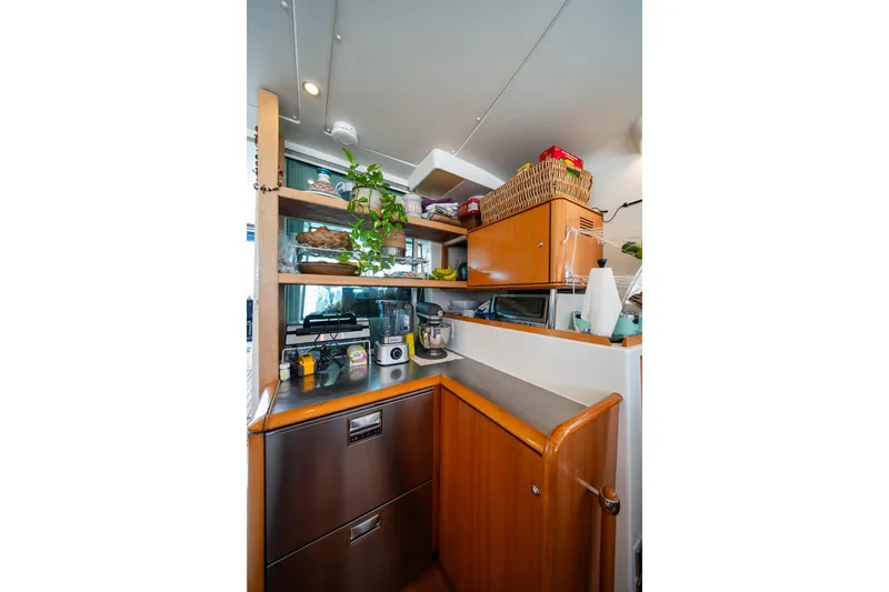  Yacht Photos Pics Compact kitchen area in a 2007 Lagoon 500 yacht with wooden cabinets and modern appliances.