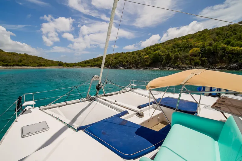  Yacht Photos Pics Lagoon 500 catamaran sailing in turquoise waters near lush green island, 2007 model.