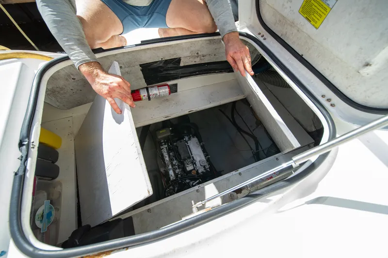  Yacht Photos Pics Man inspecting engine compartment of 2007 Lagoon 500 catamaran yacht.
