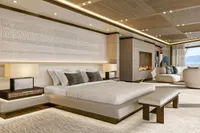 Luxurious modern bedroom with elegant decor, featuring a fireplace and panoramic ocean view.
