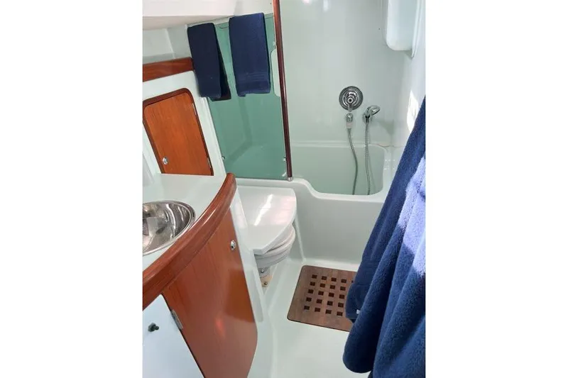  Yacht Photos Pics Bathroom interior of 1995 Beneteau Oceanis 44 CC yacht with shower and wooden accents.