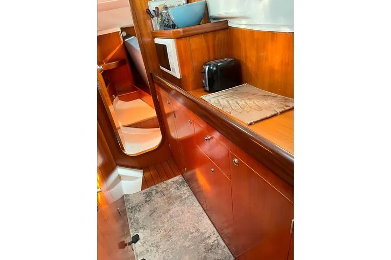  Yacht Photos Pics Interior of 1995 Beneteau Oceanis 44 CC yacht with wooden cabinetry and modern amenities.