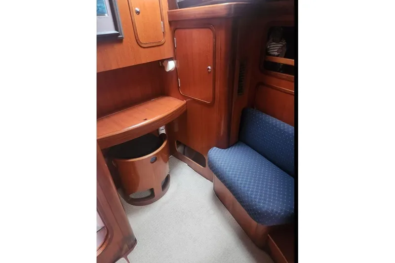  Yacht Photos Pics Interior of 1995 Beneteau Oceanis 44 CC yacht with wooden cabinetry and blue seating.