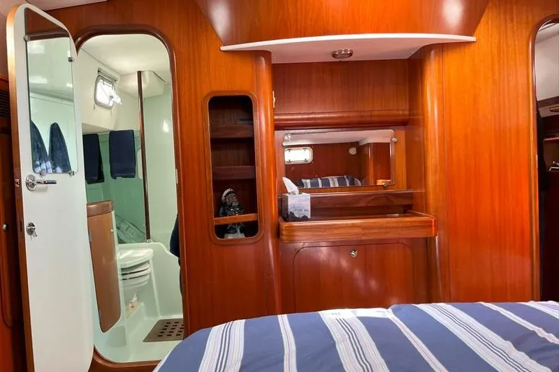  Yacht Photos Pics Interior of 1995 Beneteau Oceanis 44 CC yacht, featuring wood paneling and a compact bathroom.