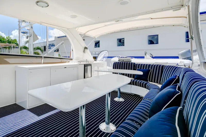 Mautica Yacht Photos Pics Luxurious 1994 Lazzara 76 yacht interior with striped seating and sleek white tables.