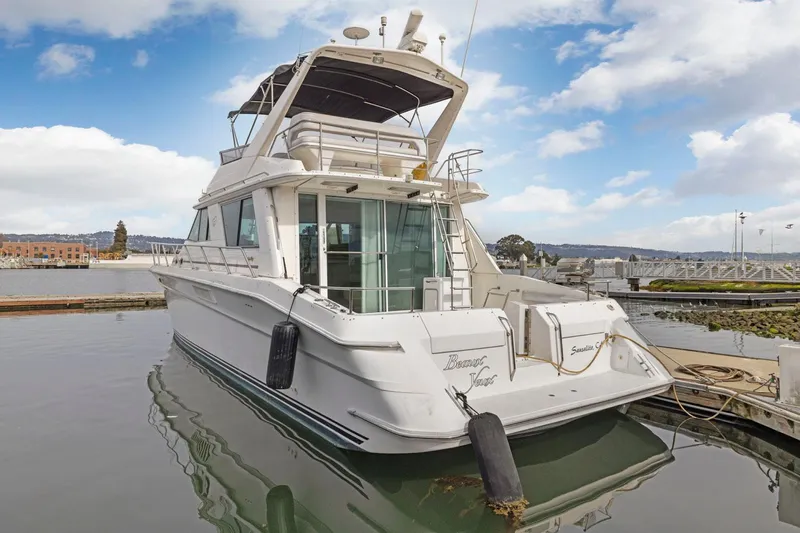  Yacht Photos Pics 1994 Sea Ray 550 Sedan Bridge yacht docked at marina under blue sky.