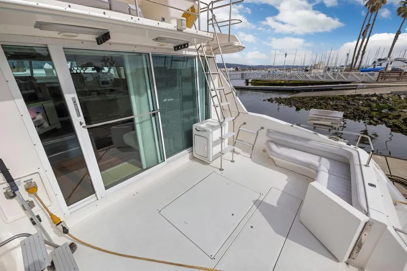  Yacht Photos Pics 1994 Sea Ray 550 Sedan Bridge yacht deck with seating, marina view, and sliding glass doors.