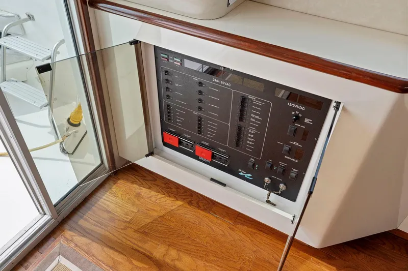  Yacht Photos Pics Electrical panel on 1994 Sea Ray 550 Sedan Bridge yacht, featuring wood flooring and glass door.