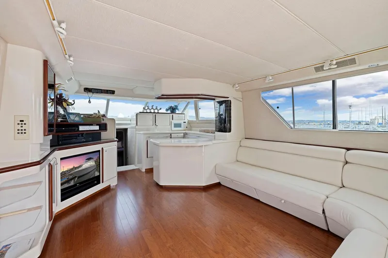  Yacht Photos Pics Luxurious interior of 1994 Sea Ray 550 Sedan Bridge yacht with white seating and wood flooring.