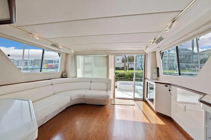  Yacht Photos Pics Luxurious interior of 1994 Sea Ray 550 Sedan Bridge yacht with white seating and wood flooring.