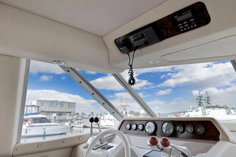  Yacht Photos Pics Interior view of 1994 Sea Ray 550 Sedan Bridge yacht with control panel and marina backdrop.