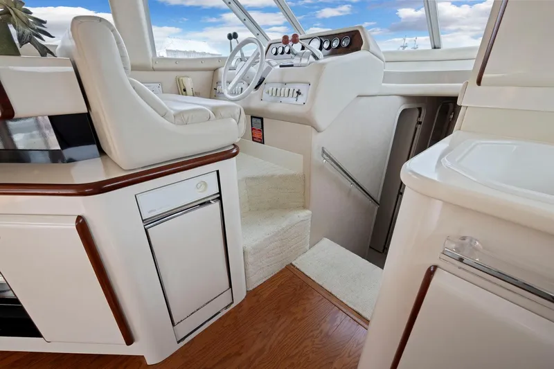  Yacht Photos Pics 1994 Sea Ray 550 Sedan Bridge helm with white leather seating and wooden accents.