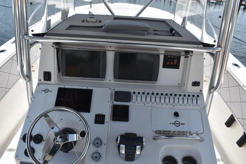 Harry's Dream Yacht Photos Pics Center console of a 2005 Fountain 38 Sportfish CC Tournament boat with steering wheel and controls.