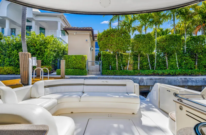 United Yacht Photos Pics Interior view of 2007 Sea Ray 480 Sundancer yacht with white seating and lush greenery outside.