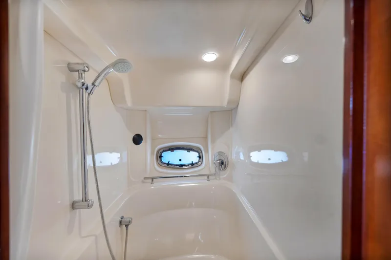 United Yacht Photos Pics Shower area in 2007 Sea Ray 480 Sundancer yacht with porthole and modern fixtures.