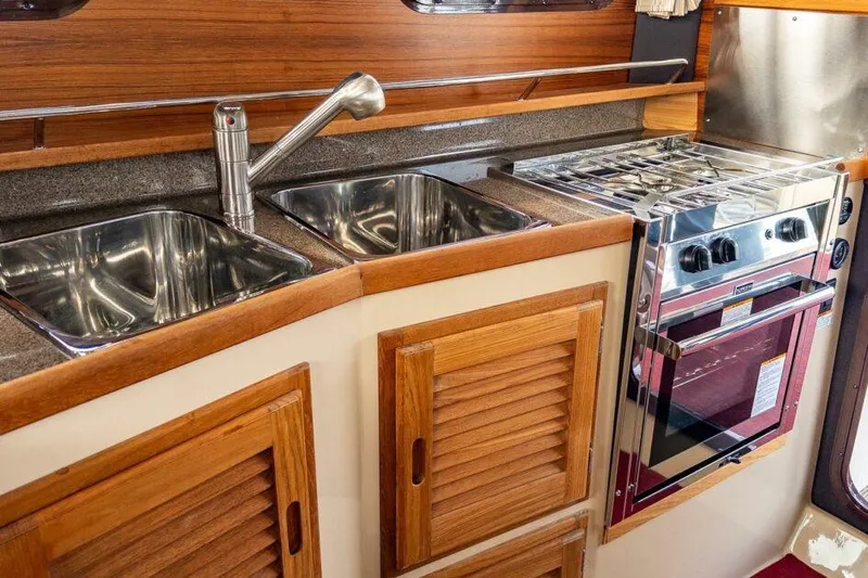 R & R Yacht Photos Pics 2019 Ranger Tugs R-31-S galley with dual sinks and stainless steel stove.