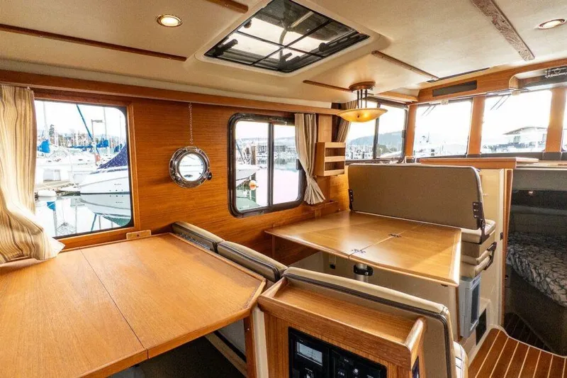 R & R Yacht Photos Pics 2019 Ranger Tugs R-31-S interior with wooden dining area and marina view.