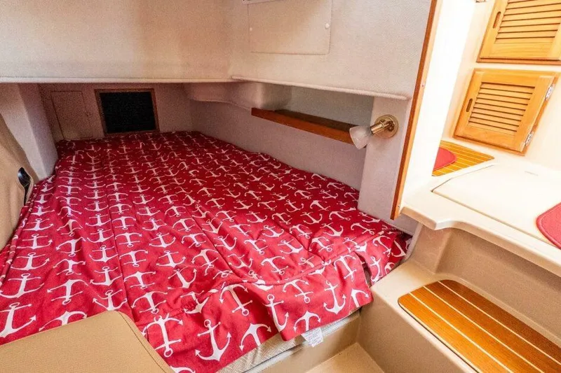 R & R Yacht Photos Pics 2019 Ranger Tugs R-31-S cabin with anchor-patterned red bedding and wooden accents.