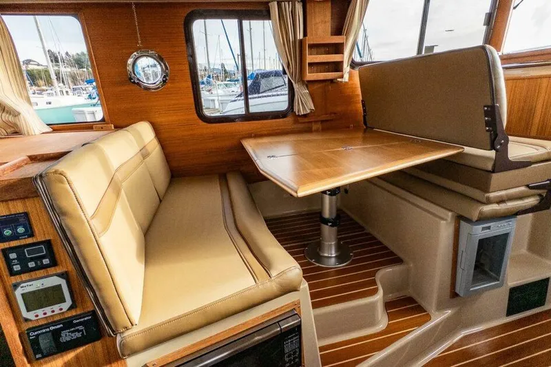 R & R Yacht Photos Pics Interior of 2019 Ranger Tugs R-31-S with beige seating and wooden table.