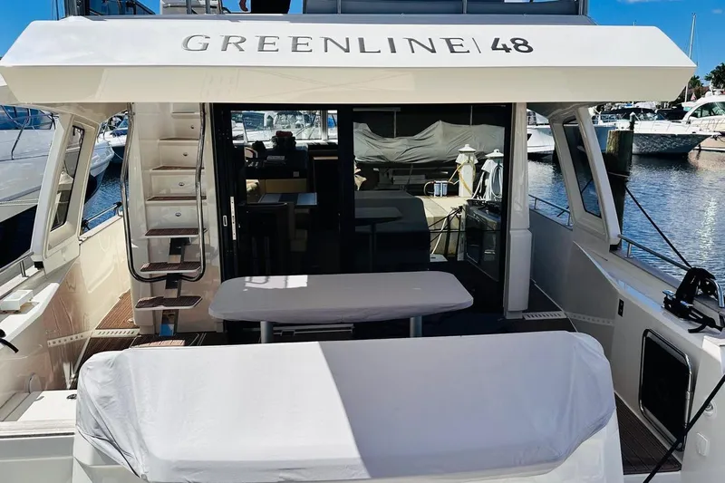 Electric Summer Yacht Photos Pics 2024 Greenline 48 Fly Hybrid yacht, rear view with seating and marina backdrop.