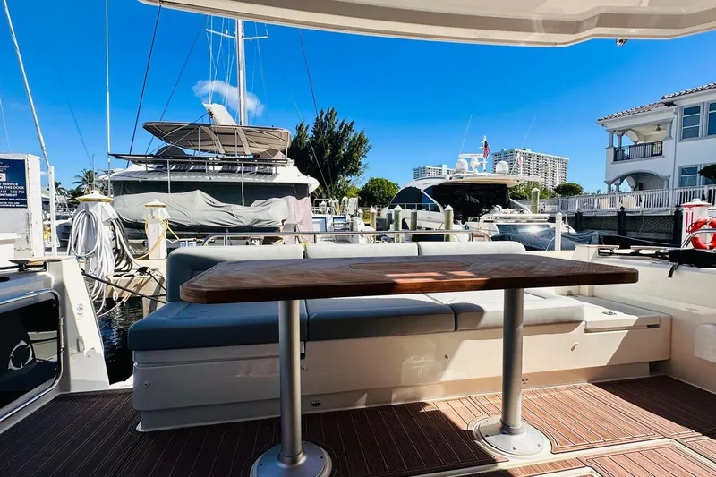 Electric Summer Yacht Photos Pics 2024 Greenline 48 Fly Hybrid yacht interior with wooden table and seating at marina.