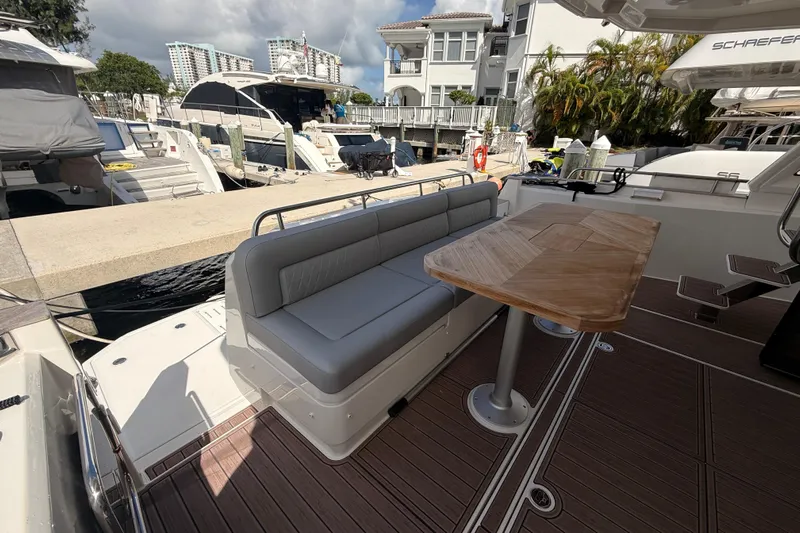 Electric Summer Yacht Photos Pics 2024 Greenline 48 Fly Hybrid yacht with outdoor seating and wooden table at marina.