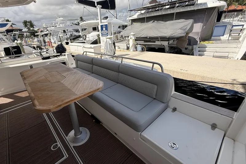 Electric Summer Yacht Photos Pics 2024 Greenline 48 Fly Hybrid yacht with outdoor seating and wooden table at marina.