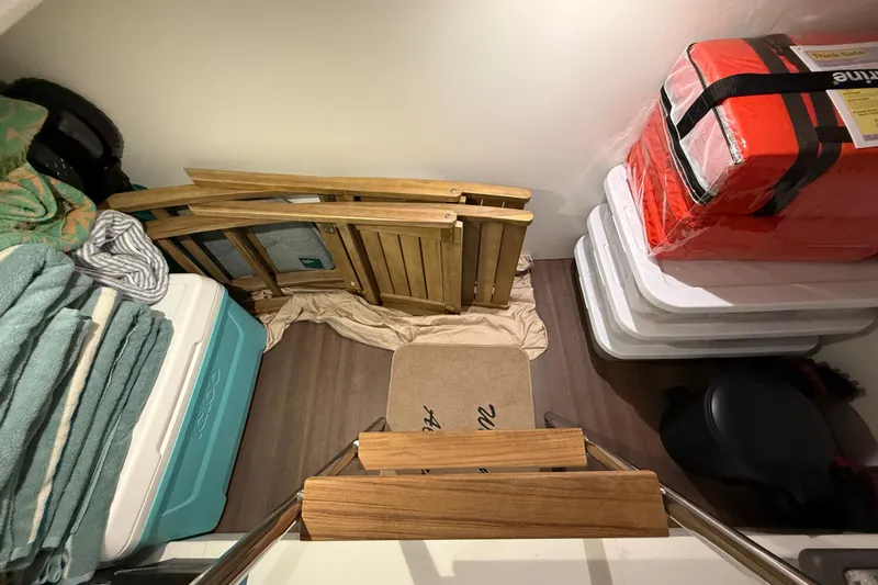 Electric Summer Yacht Photos Pics Storage area in a 2024 Greenline 48 Fly Hybrid yacht with folded chairs and coolers.