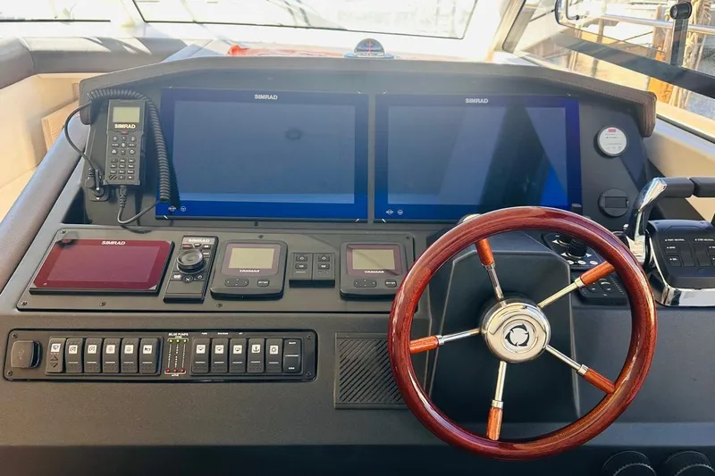 Electric Summer Yacht Photos Pics Helm of 2024 Greenline 48 Fly Hybrid yacht with advanced navigation systems and wooden steering wheel.