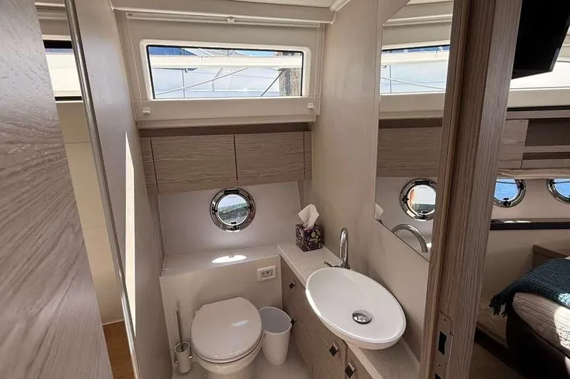 Electric Summer Yacht Photos Pics Luxurious bathroom interior of 2024 Greenline 48 Fly Hybrid yacht, featuring modern fixtures and porthole window.