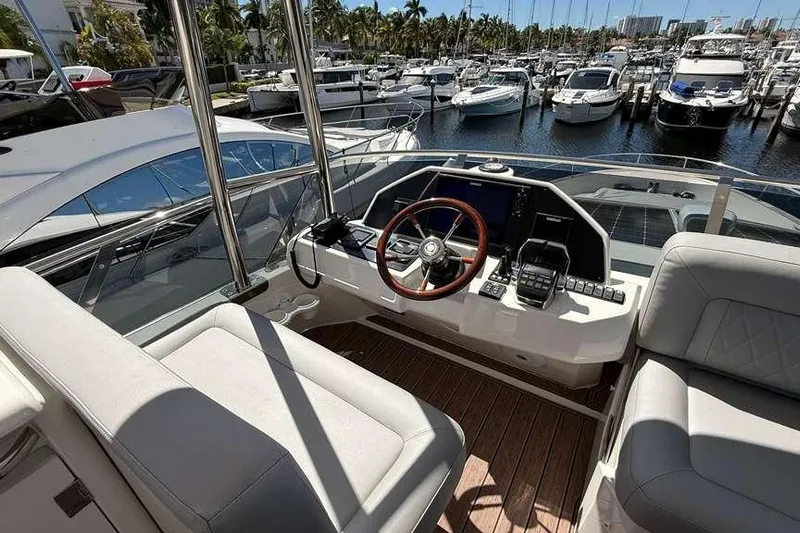 Electric Summer Yacht Photos Pics 2024 Greenline 48 Fly Hybrid yacht helm with marina view, featuring modern controls and seating.