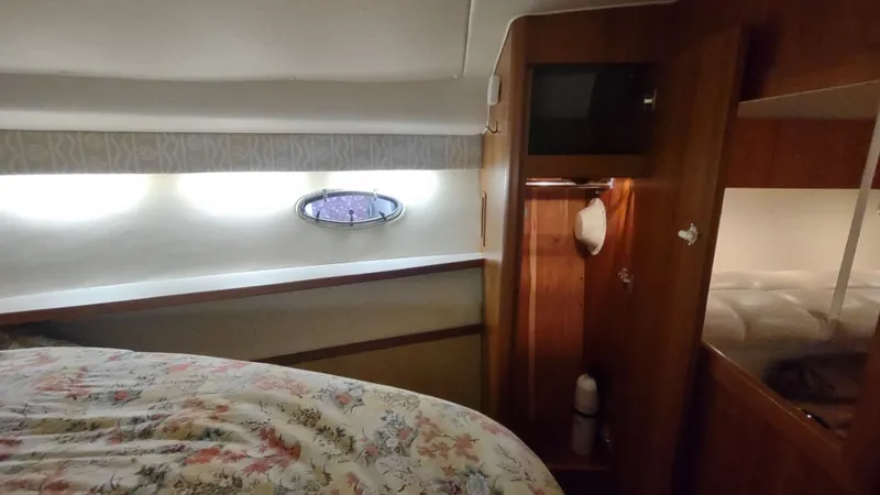  Yacht Photos Pics Cozy cabin interior of 2000 Tiara Yachts 3500 Open with floral bedding and wooden accents.