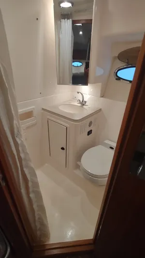  Yacht Photos Pics Compact bathroom in 2000 Tiara Yachts 3500 Open, featuring sink, toilet, and shower.