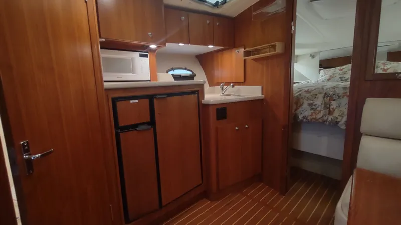 Yacht Photos Pics 2000 Tiara Yachts 3500 Open interior with kitchenette and cozy sleeping area.
