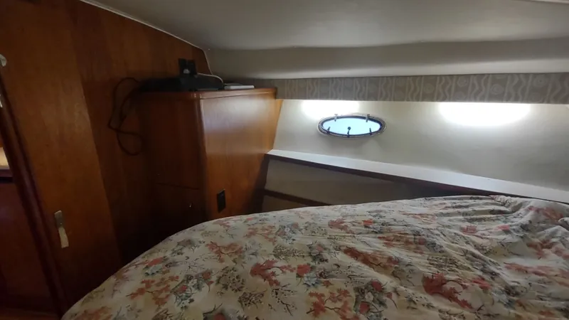  Yacht Photos Pics Cozy cabin interior of 2000 Tiara Yachts 3500 Open with floral bedding and porthole window.