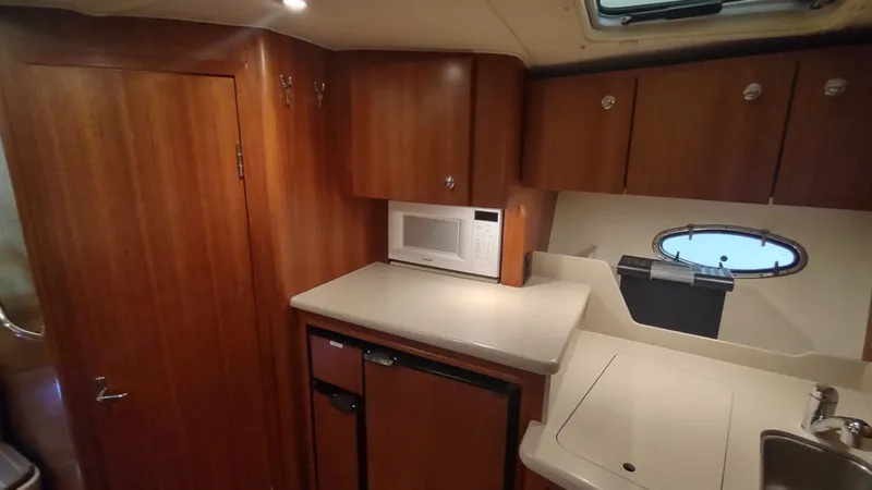  Yacht Photos Pics Interior of 2000 Tiara Yachts 3500 Open, featuring a compact kitchen with wood cabinetry.