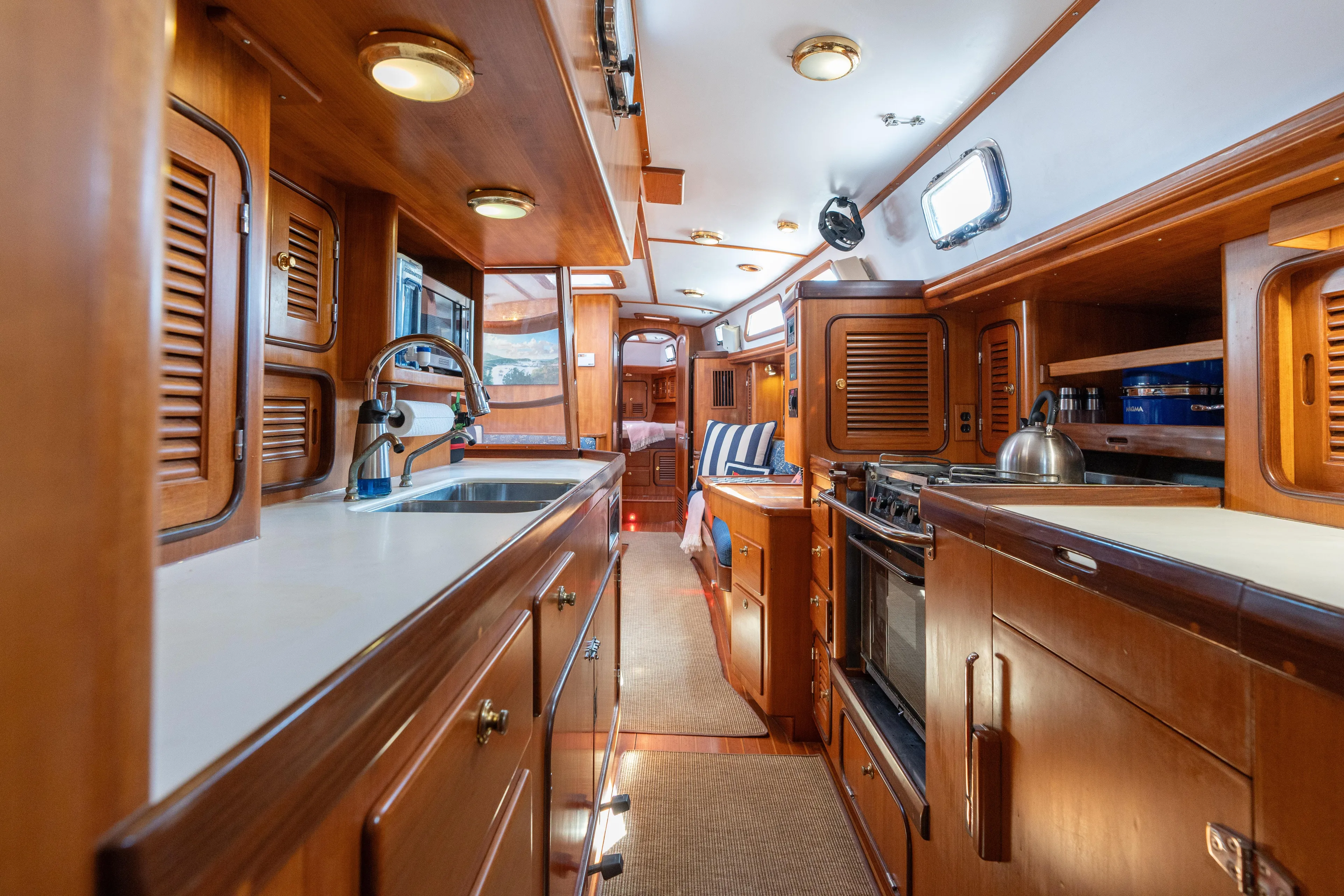 Altair Yacht Photos Pics Luxurious 2002 Passport 470 Center Cockpit Ketch interior with wood cabinetry and modern amenities.