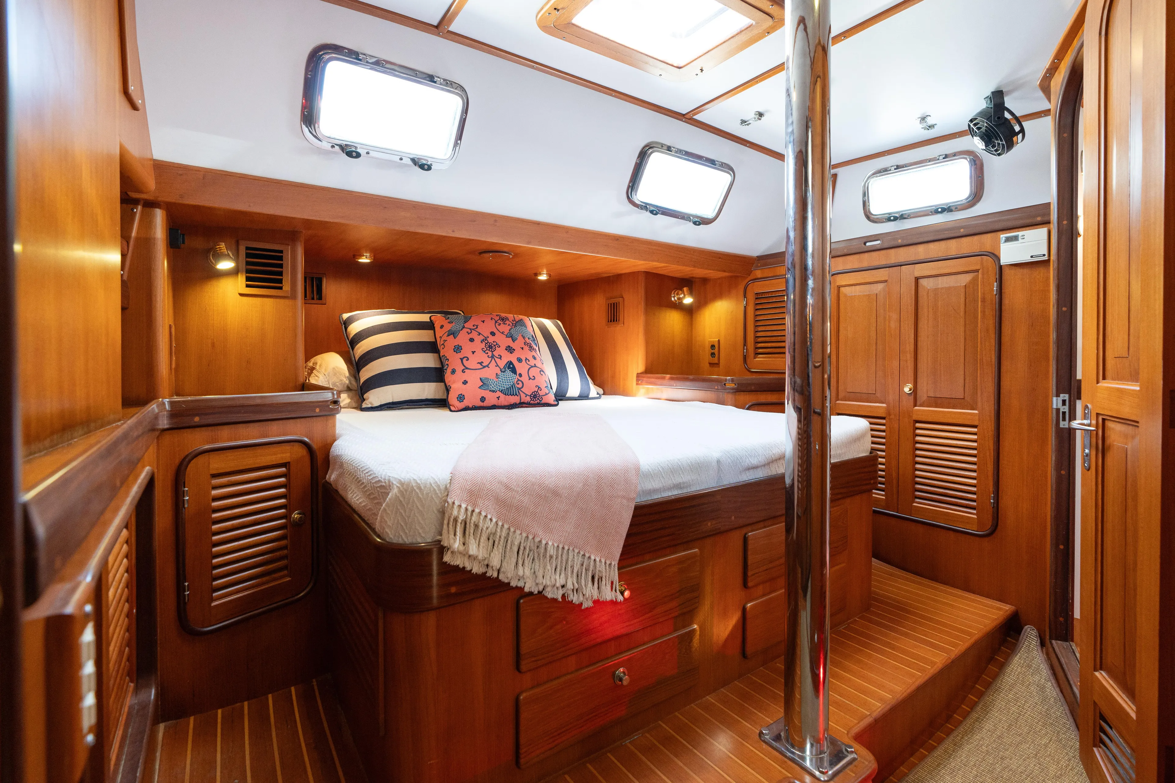 Altair Yacht Photos Pics Luxurious cabin interior of 2002 Passport 470 Center Cockpit Ketch, featuring wood finishes and cozy bedding.