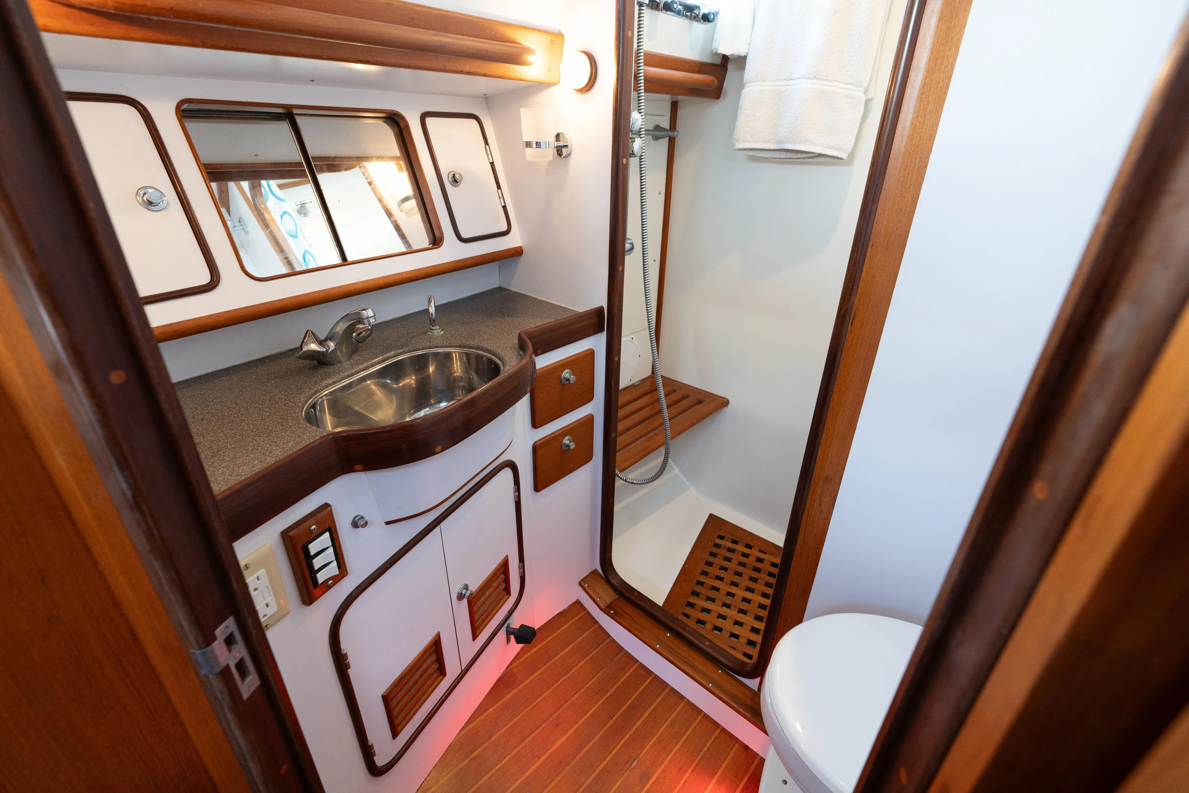 Altair Yacht Photos Pics Luxurious bathroom in 2002 Passport 470 Center Cockpit Ketch yacht, featuring wood accents and modern fixtures.