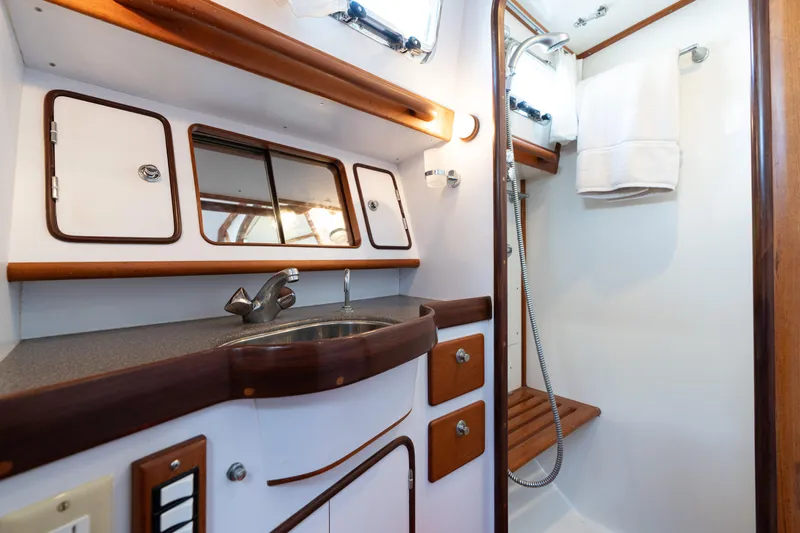 Altair Yacht Photos Pics Luxurious bathroom in 2002 Passport 470 Center Cockpit Ketch yacht with wood accents and modern fixtures.