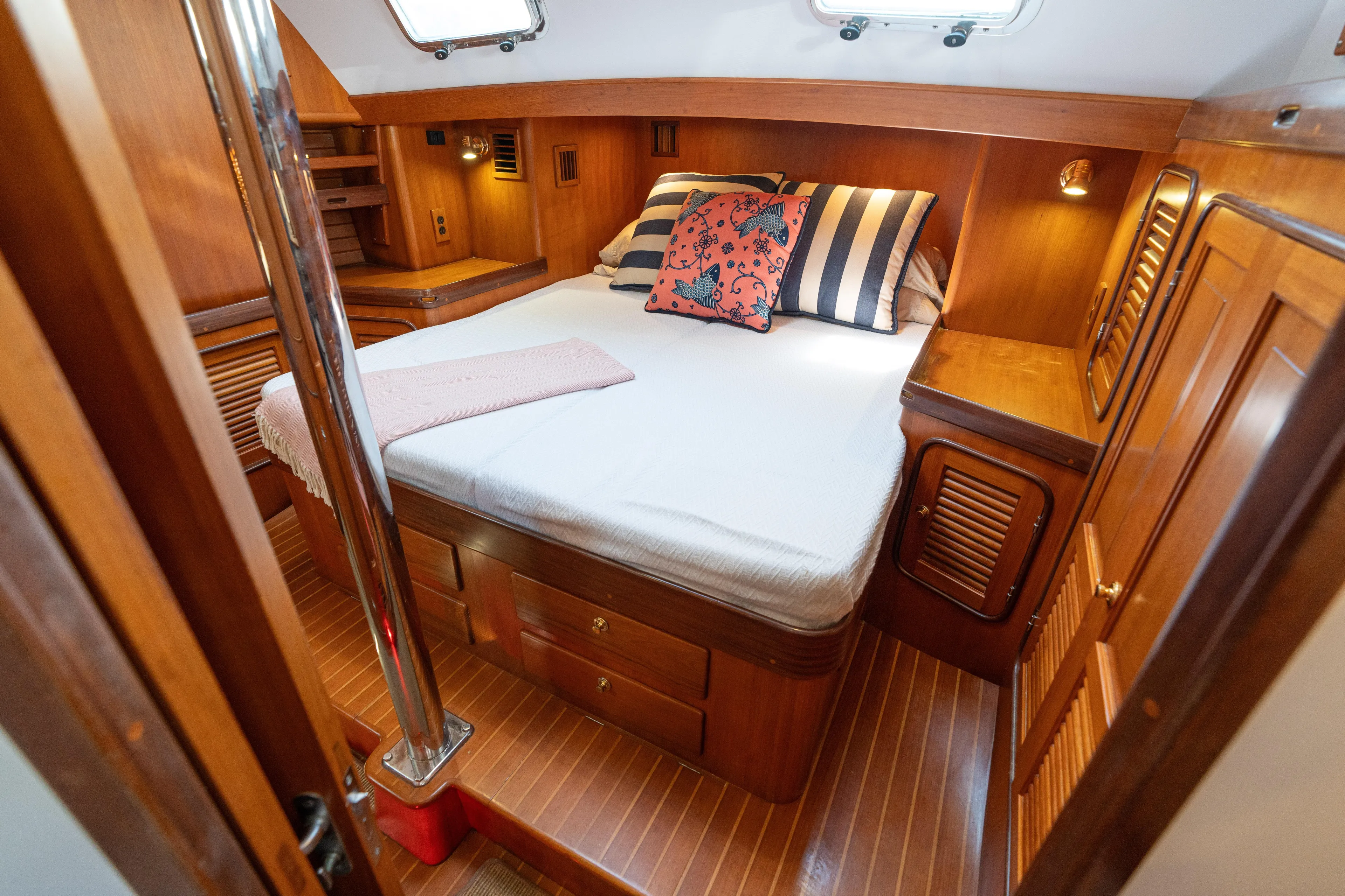 Altair Yacht Photos Pics Cozy cabin interior of 2002 Passport 470 Center Cockpit Ketch with wooden furnishings and bed.