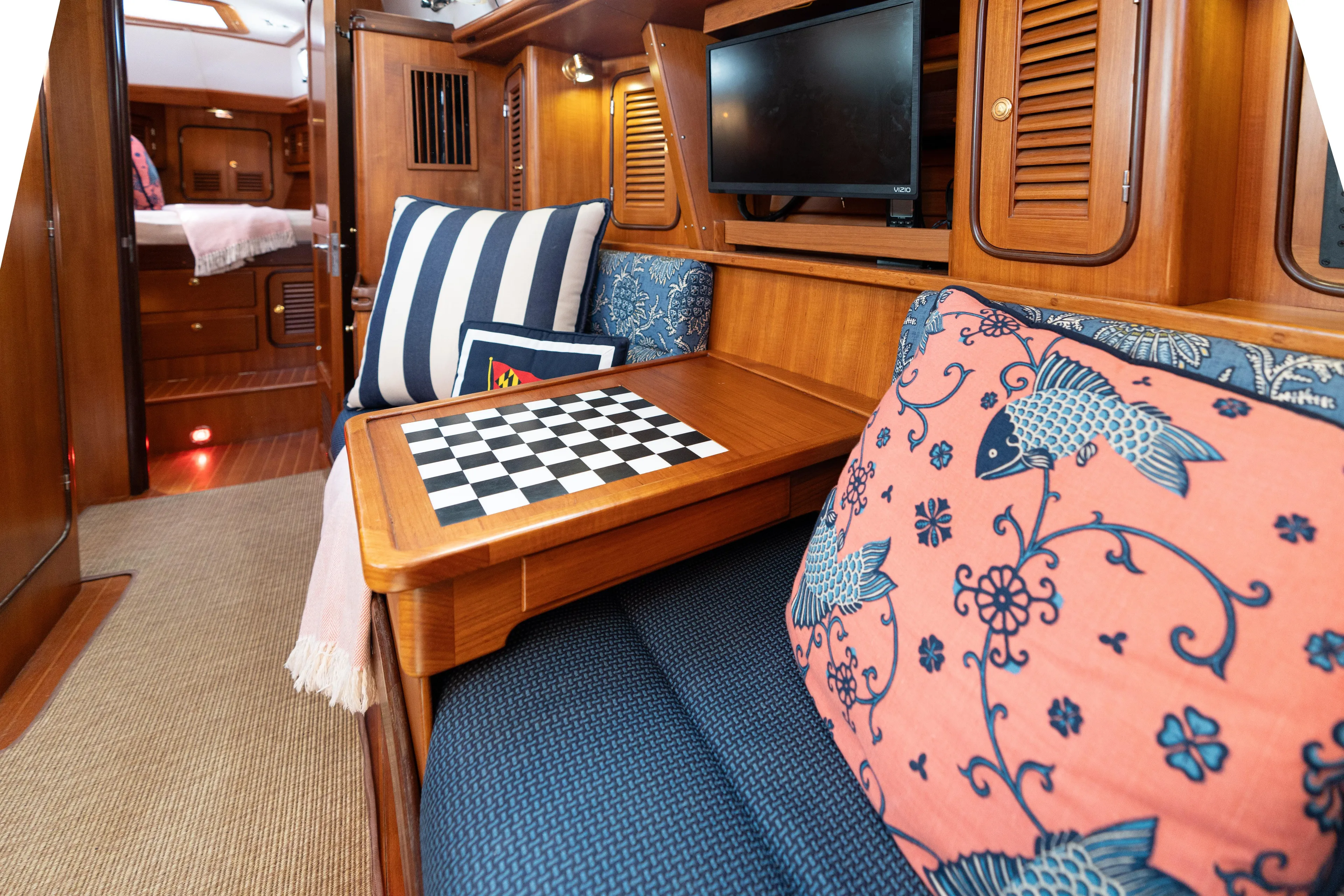 Altair Yacht Photos Pics Cozy interior of 2002 Passport 470 Center Cockpit Ketch with chessboard and decorative pillows.