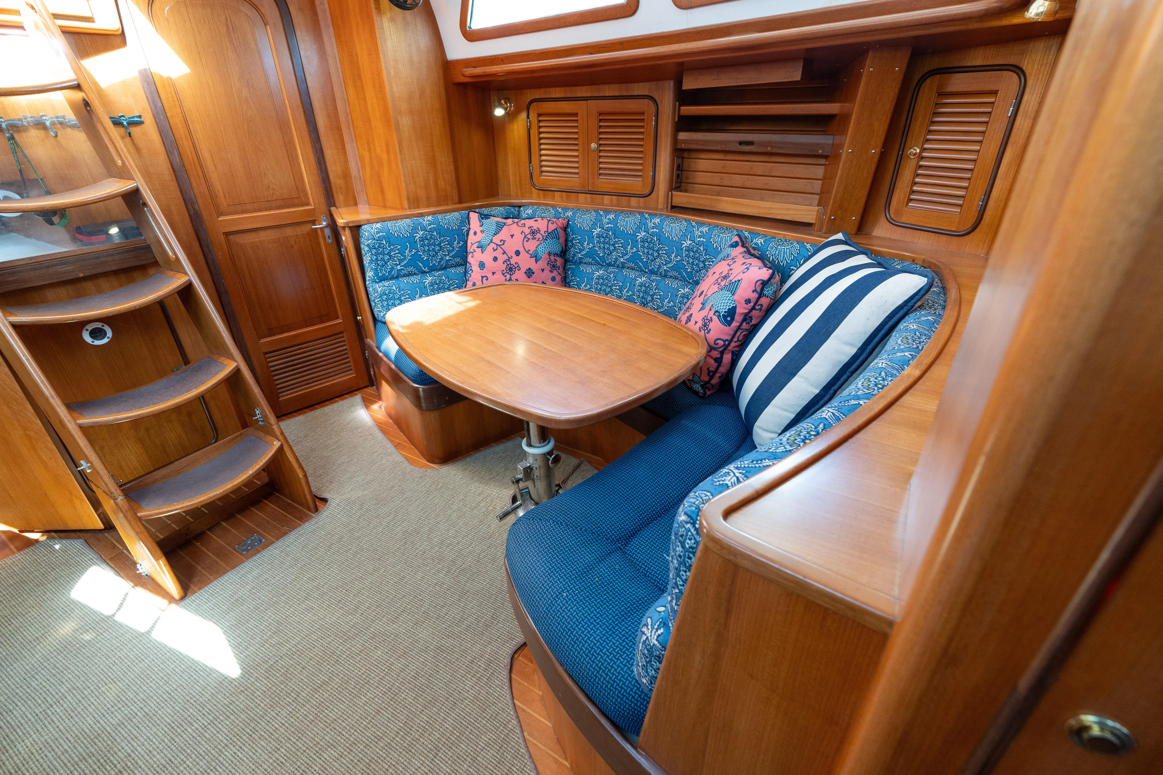 Altair Yacht Photos Pics Cozy interior of 2002 Passport 470 Center Cockpit Ketch with wooden finish and cushioned seating.