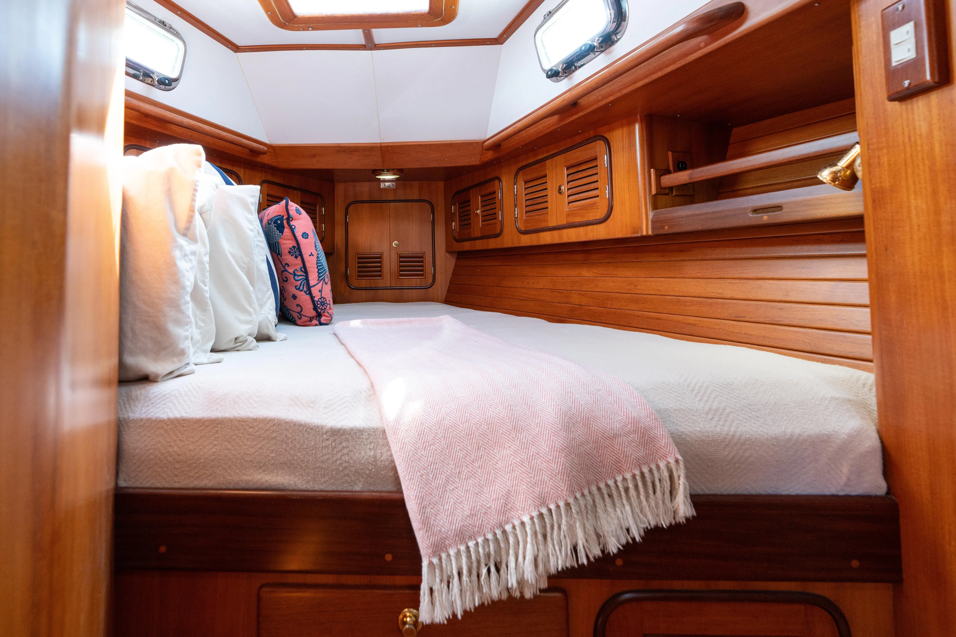 Altair Yacht Photos Pics Cozy cabin interior of 2002 Passport 470 Center Cockpit Ketch with wooden finish and bedding.