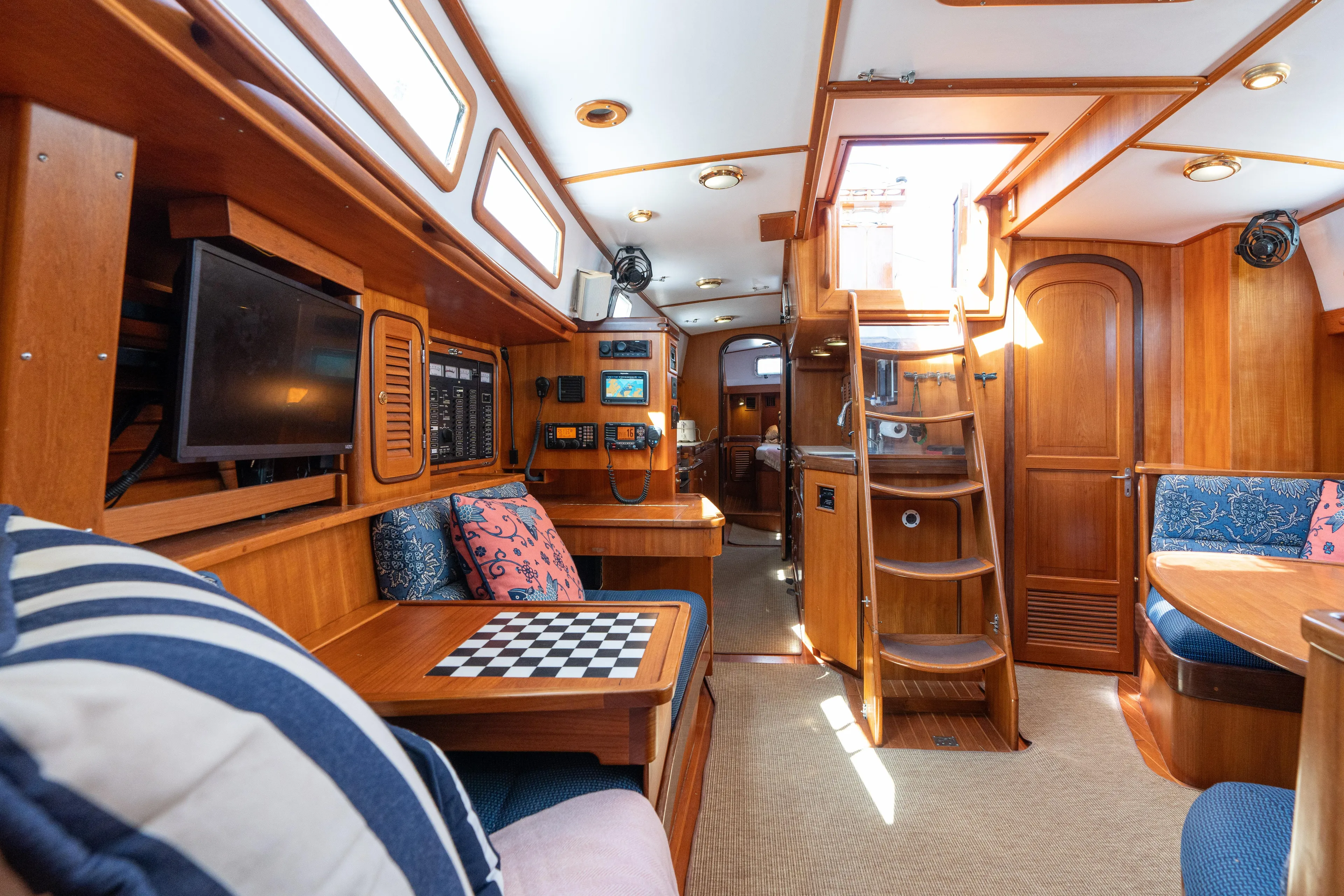 Altair Yacht Photos Pics Interior of 2002 Passport 470 Center Cockpit Ketch, featuring wood paneling and cozy seating.