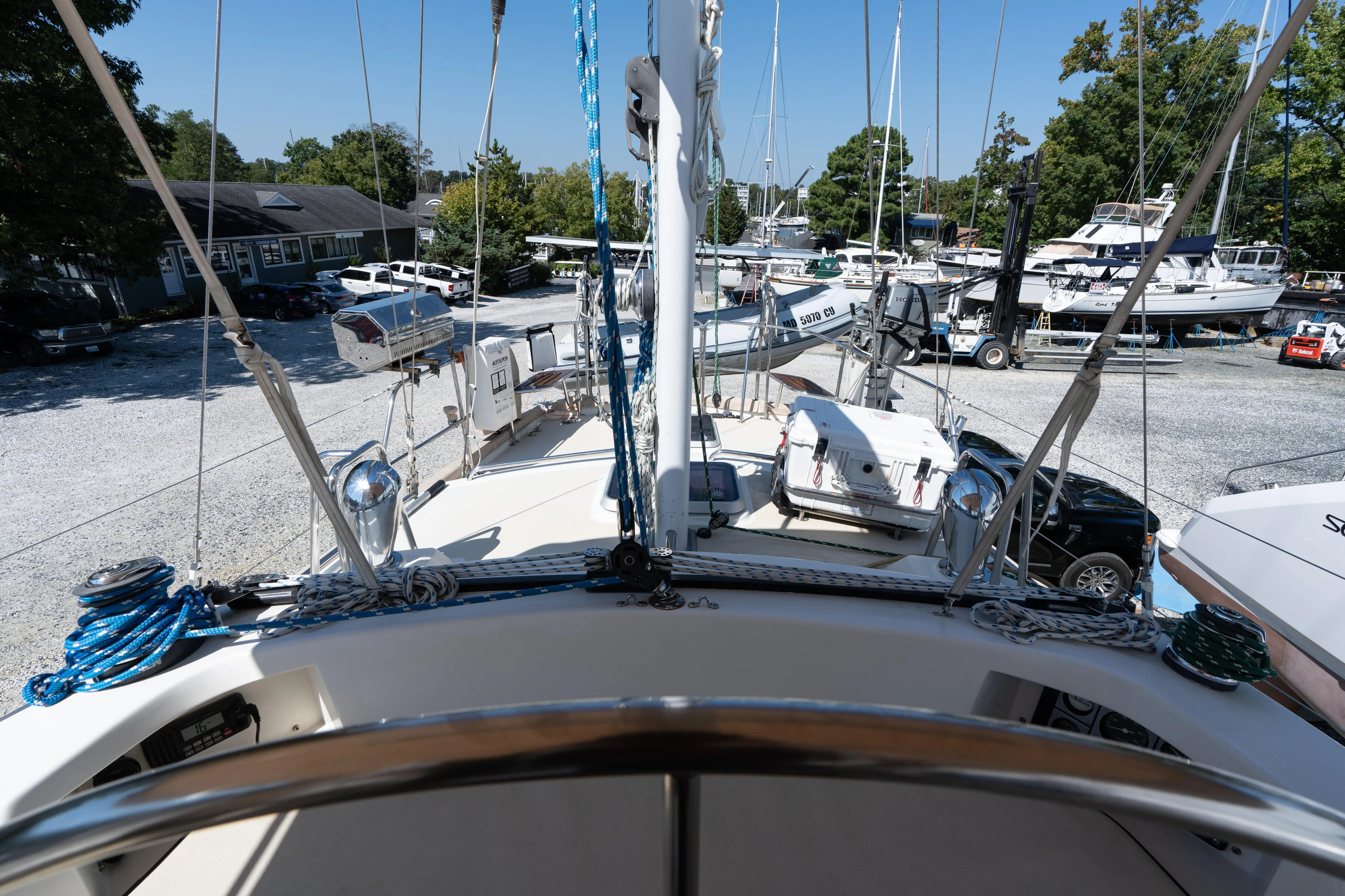 Altair Yacht Photos Pics 2002 Passport 470 Center Cockpit Ketch in marina, surrounded by boats and vehicles.